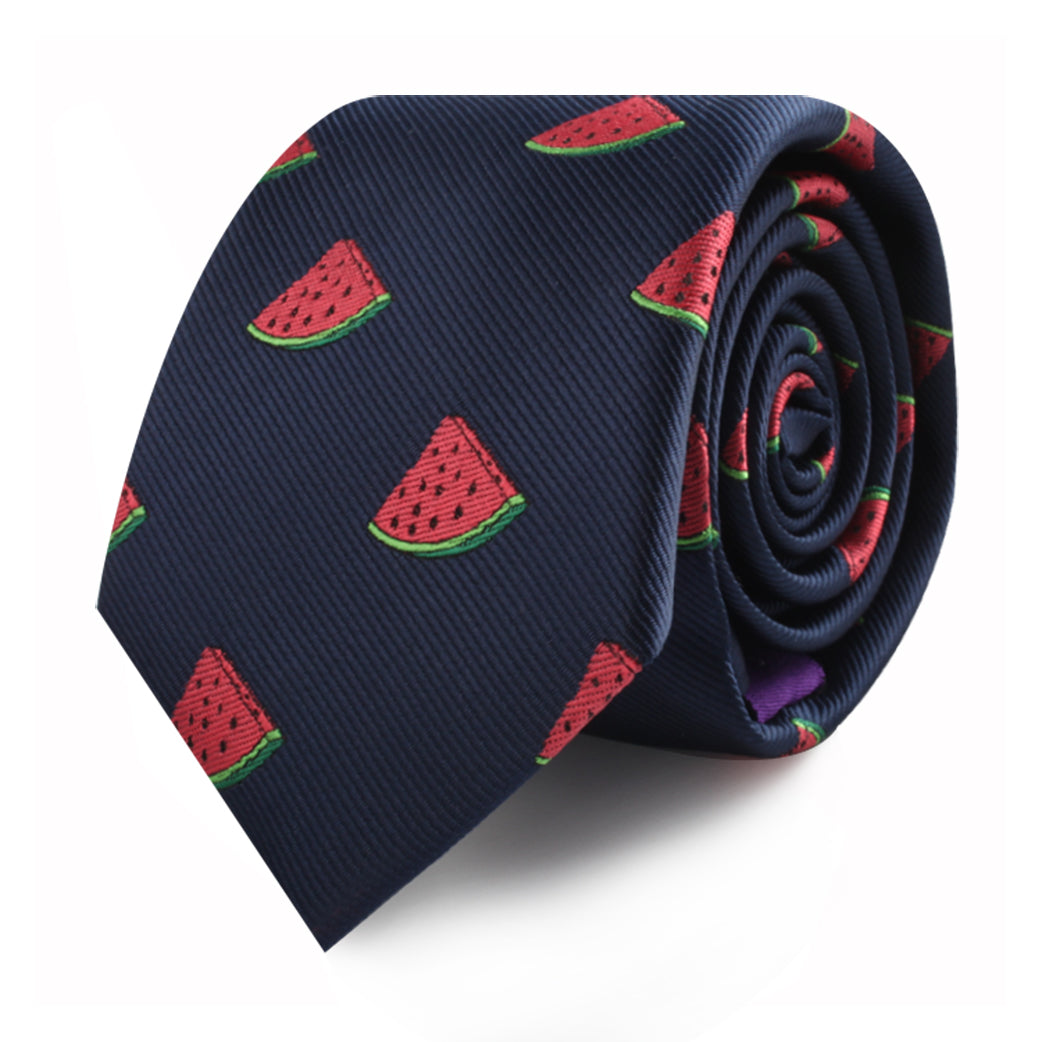 A rolled-up Watermelon Skinny Tie, featuring a pattern of red and green watermelon slices, perfect for adding a touch of summertime freshness to your style.