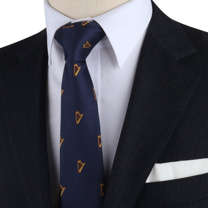 Close-up of a mannequin wearing a dark pinstripe suit, white shirt, and navy Harp Skinny Tie with gold diamond patterns, orchestrated to showcase elegance.