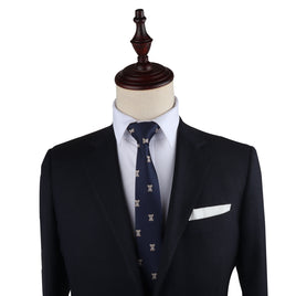 A suit display showcasing a dark suit jacket, white dress shirt, and Koala Skinny Tie on a mannequin torso with a wooden top piece exudes undeniable charm.