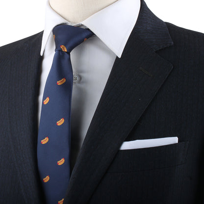 A mannequin exudes charisma, dressed in a dark suit with a white shirt and the Hotdog Skinny Tie, which features small orange and yellow patterns. A white pocket square is neatly tucked into the suit jacket's pocket.