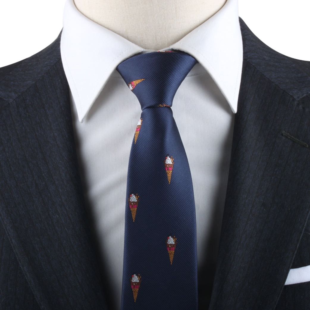 Close-up of a mannequin showcasing a dark blue suit and an Ice Cream Skinny Tie featuring a subtle pattern with red and gold accent designs, radiating impeccable style.