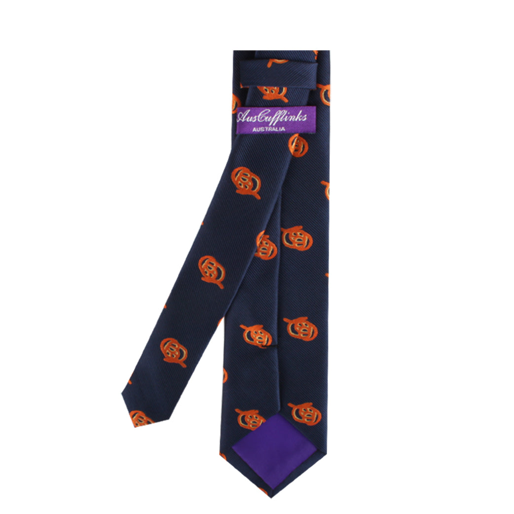 The Pretzel Skinny Tie, in a dark blue shade adorned with orange pumpkin designs, adds a unique twist of festive charisma and features a distinct purple label that reads "Australia.