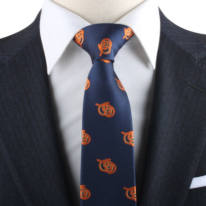 A person in a dark suit and white shirt exudes charisma, wearing the Pretzel Skinny Tie adorned with an orange pumpkin pattern.