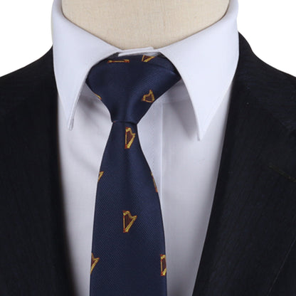 Close-up view of a Harp Skinny Tie with yellow triangle patterns, orchestrated elegantly in a neat knot, worn with a white shirt and dark suit jacket.