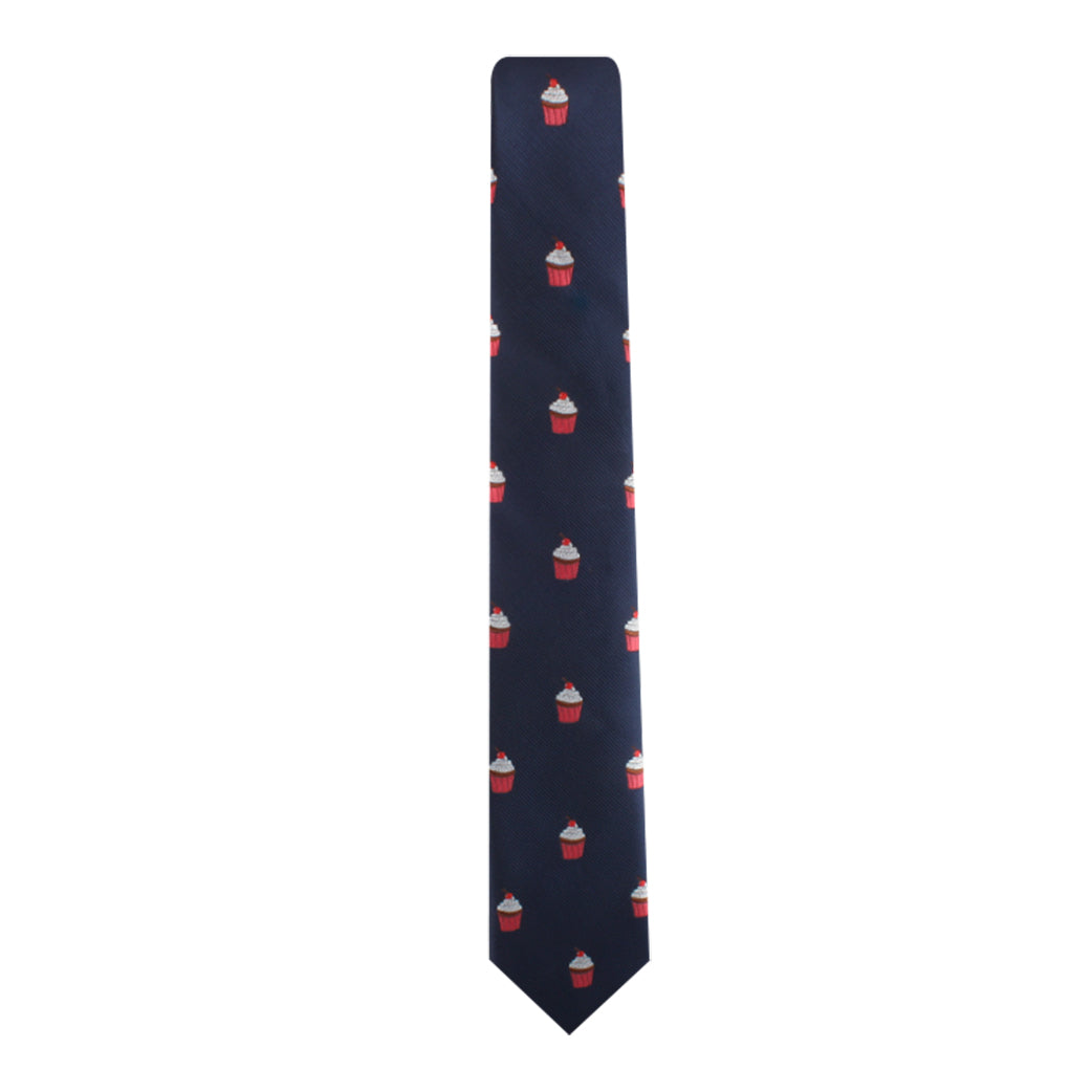 The Muffin Skinny Tie, featuring a navy blue design adorned with a pattern of small red and white cupcakes, makes a delectable style statement.