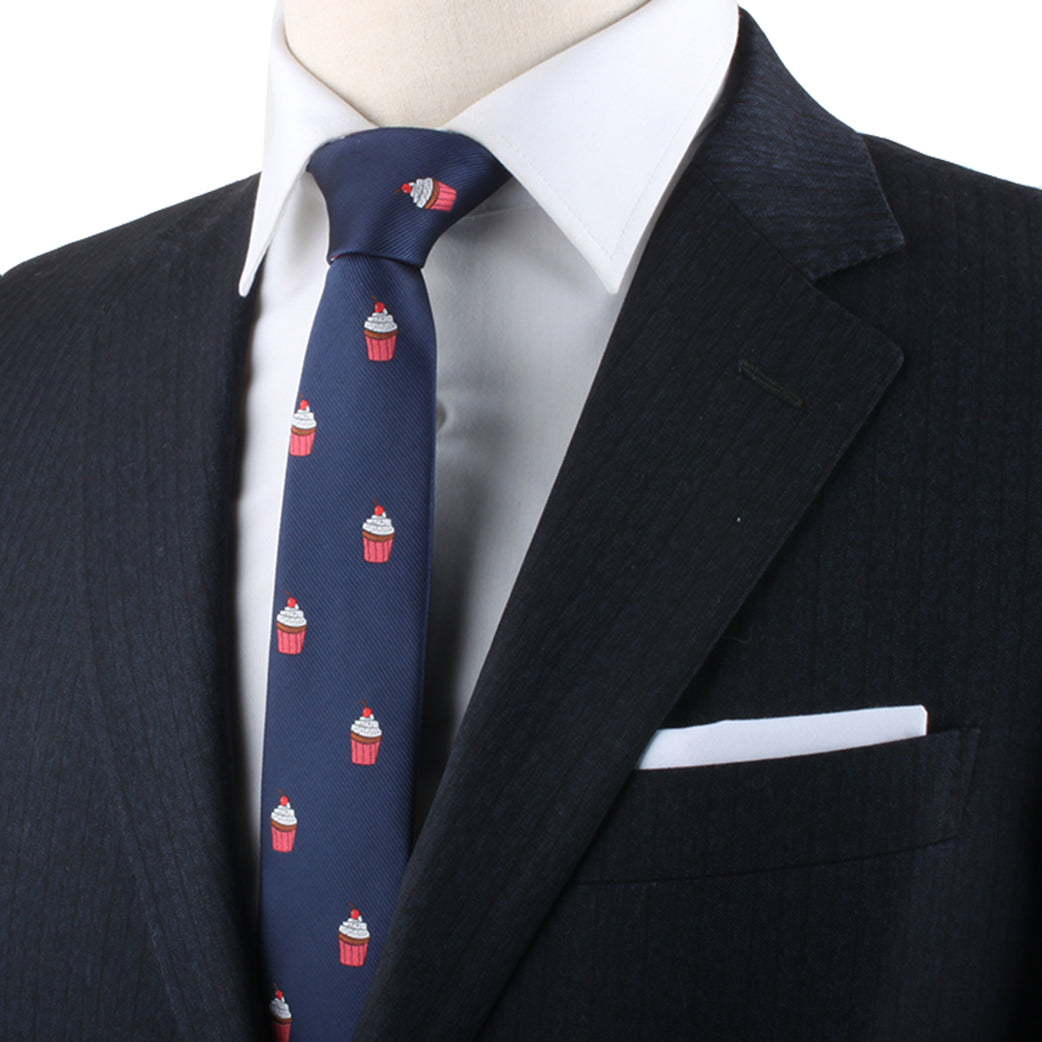 A person makes a delectable style statement in a dark suit with a white shirt and the Muffin Skinny Tie featuring a charming cupcake pattern.