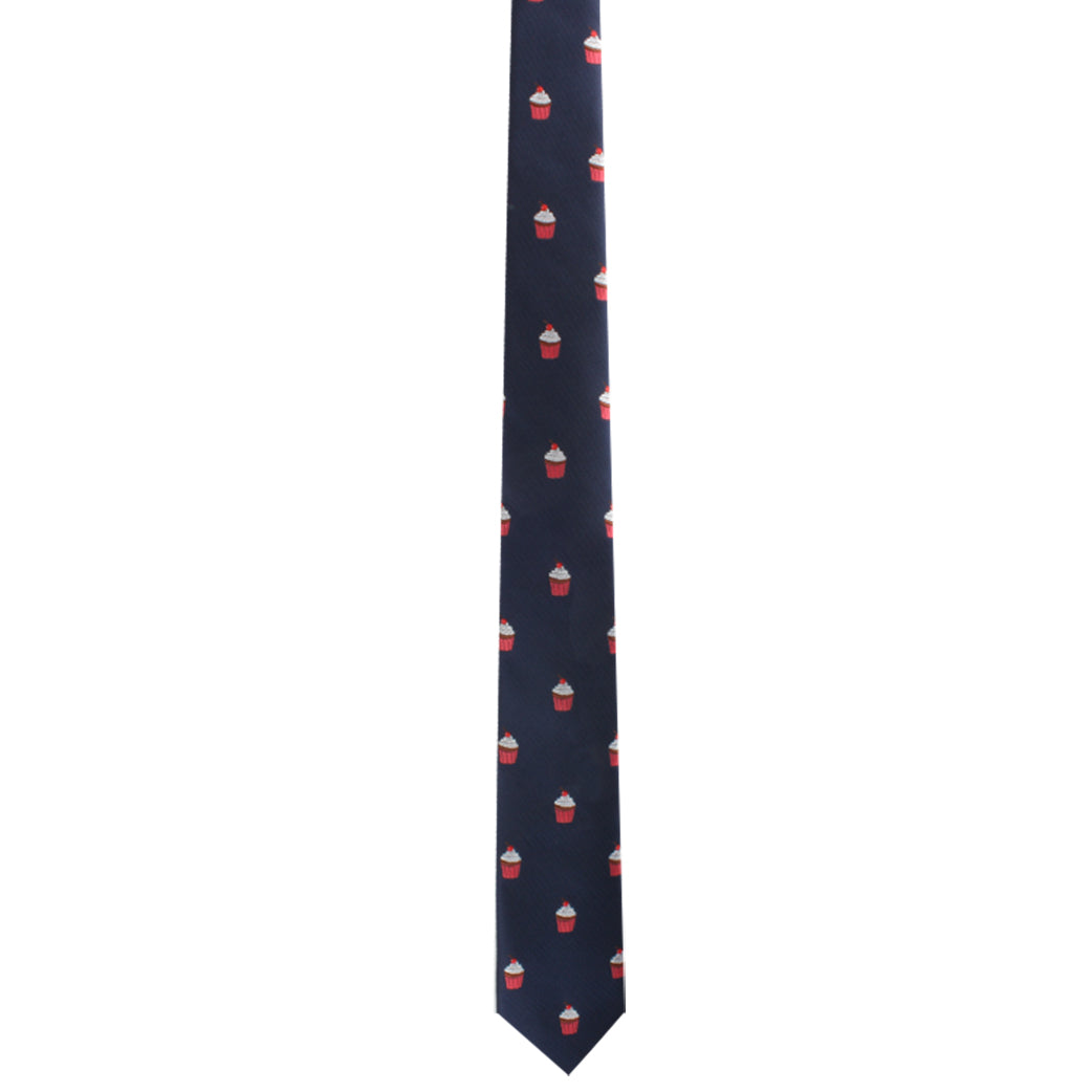 Experience a delectable style statement with the Muffin Skinny Tie in dark blue, featuring a pattern of small white and red cupcake icons.