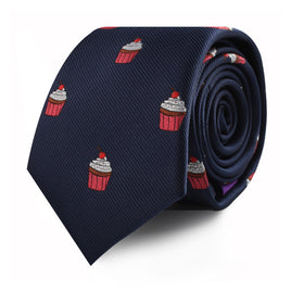 The Muffin Skinny Tie in navy blue, featuring a pattern of red cupcakes, makes a delectable style statement.