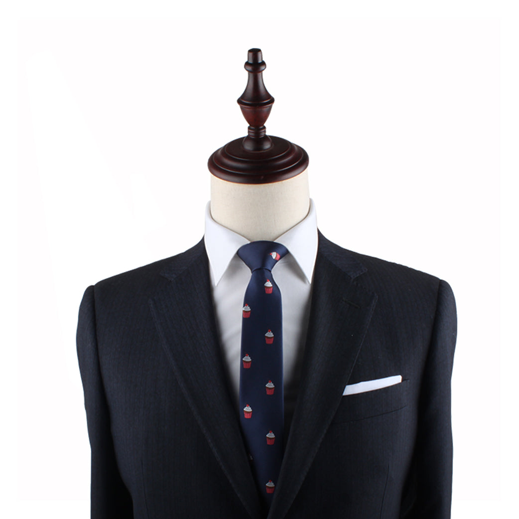 A mannequin dressed in a dark suit makes a delectable style statement with its crisp white shirt and the Muffin Skinny Tie against a white background.