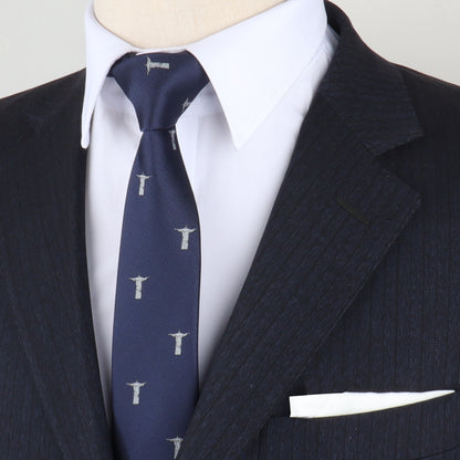 Close-up of a person wearing a dark pinstripe suit and white shirt, paired with the Jesus Christ The Redeemer Skinny Tie featuring small patterned designs, embodying a stylish form. A white pocket square is visible in the jacket pocket.