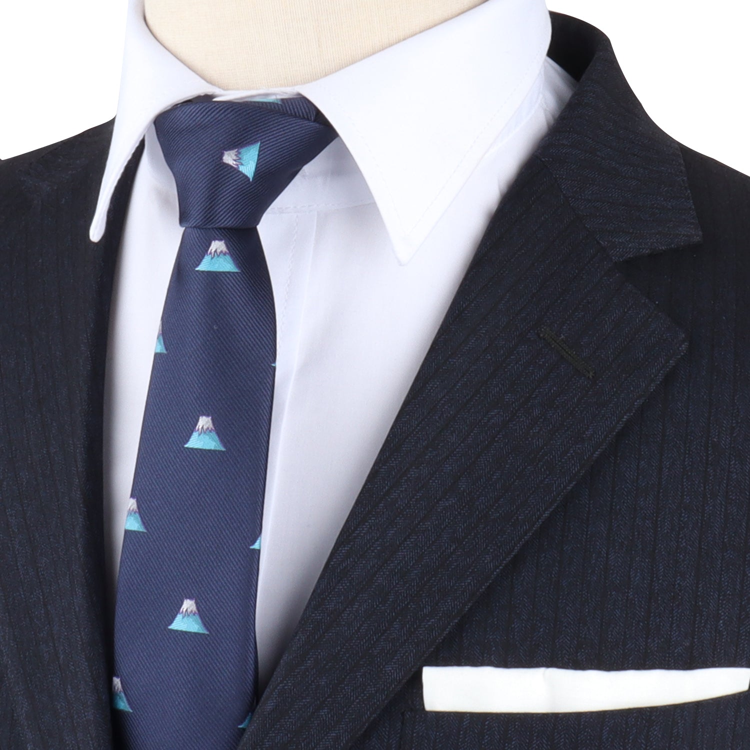 A close-up of a person wearing a dark pinstripe suit and white shirt showcases the Mountain Skinny Tie, adorned with mountain patterns, capturing the beauty of nature seamlessly woven into classic style.