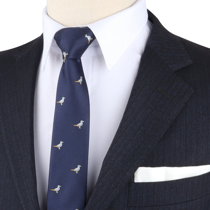 Close-up of a person in a dark pinstripe suit and white shirt, wearing the Seagul Skinny Tie featuring bird patterns that seem to soar, complemented by a white pocket square. A standout style suitable for any occasion from coast to coast.