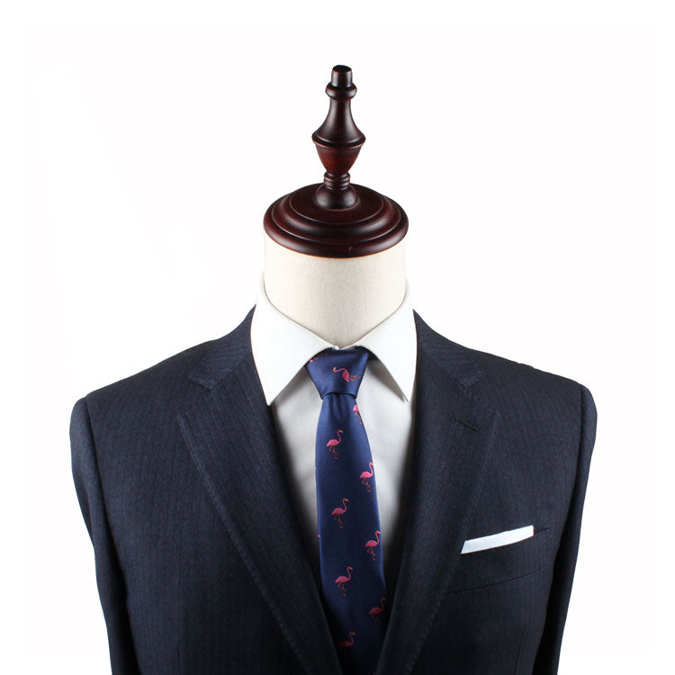 A mannequin displays a dark suit jacket over a white shirt, enhanced by the Flamingo Skinny Tie with its playful pattern, adding a touch of whimsical style.