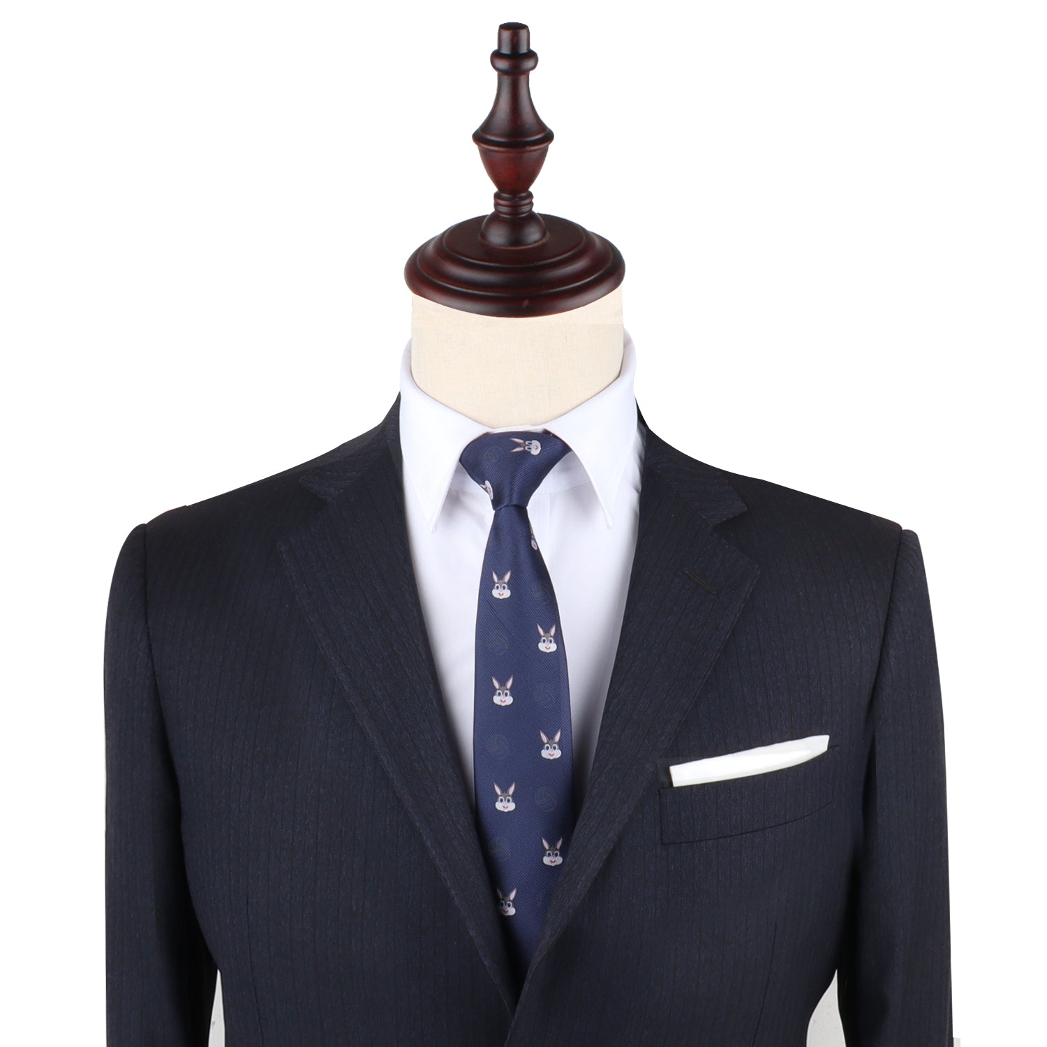 A mannequin exudes charming sophistication in a dark suit paired with a white shirt and the Bunny Skinny Tie. The ensemble is accented by a white pocket square, showcasing elegant clothing that speaks to sophisticated fashion.