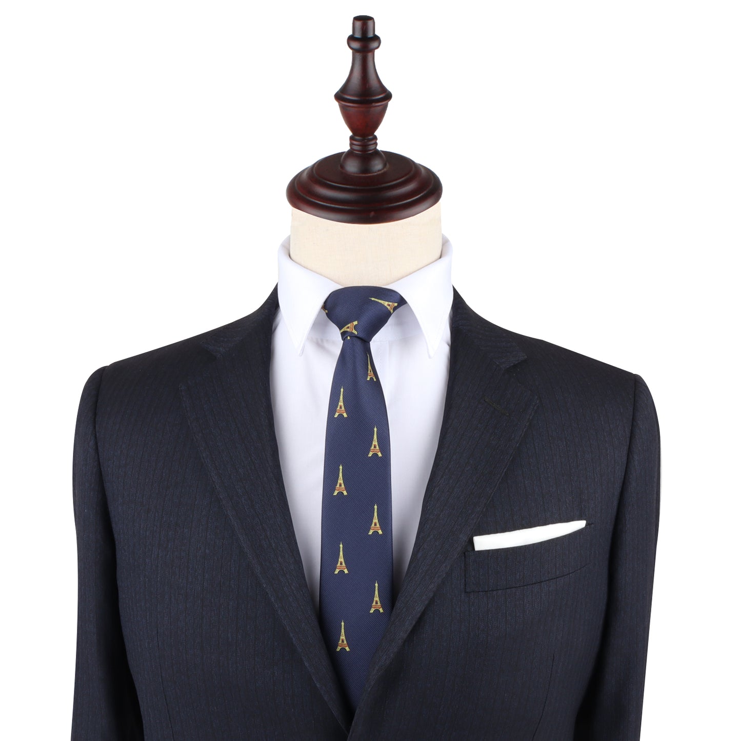 A mannequin dressed in a dark suit with a white dress shirt and an Eiffel Tower Skinny Tie exudes Parisian elegance. A white pocket square is neatly tucked into the jacket's breast pocket, completing the sophisticated woven look.