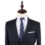 A mannequin dressed in a dark suit with a white dress shirt, the Sail Boat Skinny Tie featuring small sailboat patterns, and a white pocket square embodies nautical style.