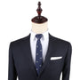 Displayed on a mannequin, a navy suit paired with a white dress shirt and the Seagul Skinny Tie, which features small bird patterns, captures timeless style and lets one's confidence soar.