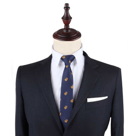 Navy blue suit with Treasure Chest Skinny Tie and white pocket square displayed on a headless mannequin, designed as attire for any uncover adventure.