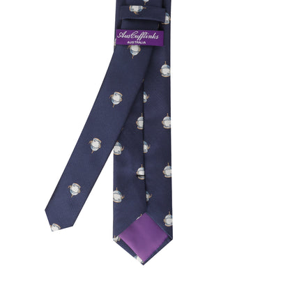 Introducing the Spaceman Skinny Tie: a blue necktie adorned with a pattern of small owl graphics, featuring a purple label with "AusCufflinks AUSTRALIA" on the inner part, designed to elevate your style to new galaxies.