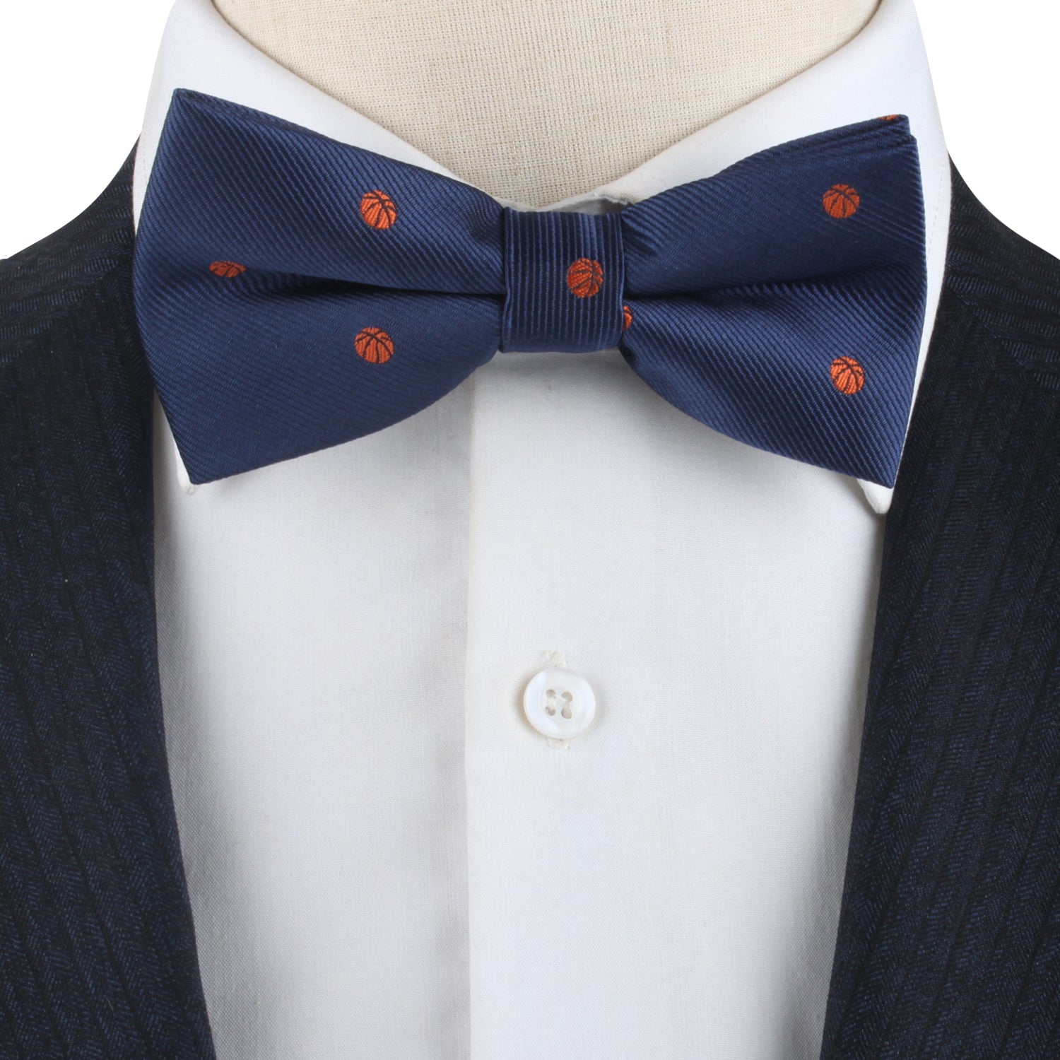 A mannequin wearing a Basketball Bow Tie with orange dots in a fashionable manner.