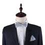 A mannequin dressed in a dark suit, white shirt, and a Black Light Blue Floral Bow Tie with a matching pocket square creates a timeless combo.