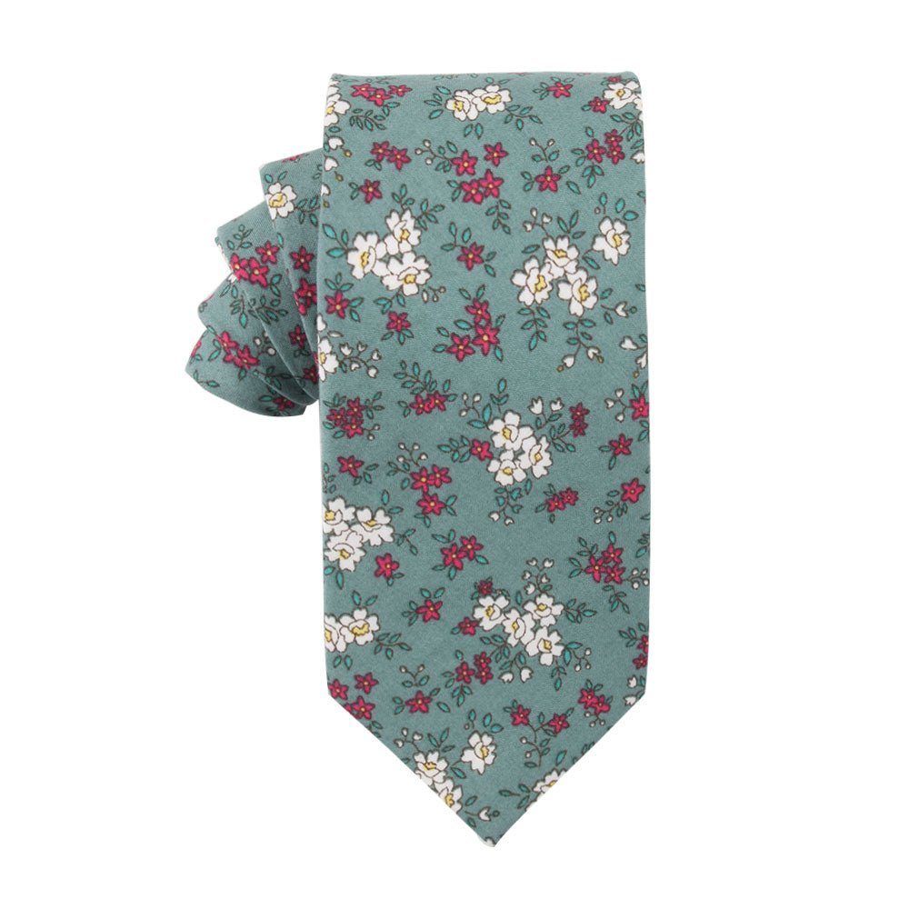 The Teal Floral Skinny Cotton Tie, featuring a sophisticated design of small white and red flowers, exudes an elegant charm with its timeless navy accents.