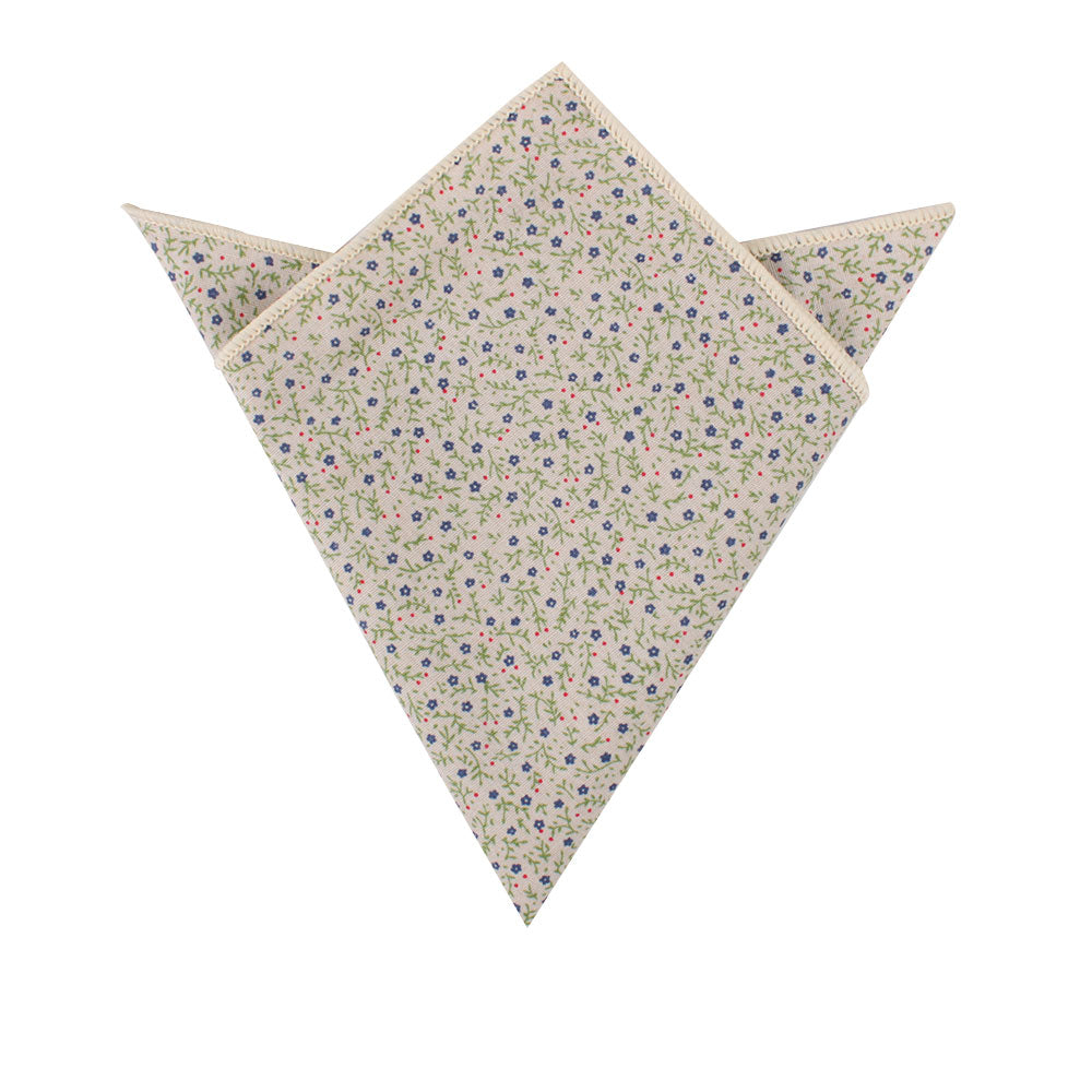 A folded pocket square featuring an elegant floral design with hints of blue on a white background from the Blue Forget-Me-Nots Cotton Floral Skinny Tie & Pocket Square Set.