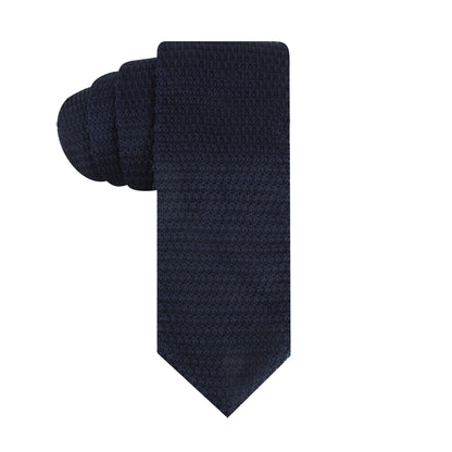 A Blue Knitted Tie, reminiscent of the deep-sea, is elegantly rolled on a white background.