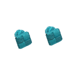 Two teal woven fabric knots exude timeless elegance, reminiscent of the classic style of Turquoise Square Cufflinks, against a white background.