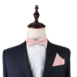 A man in a suit with a Blush Pink Bow Tie and Pocket Square Set exuding elegance.