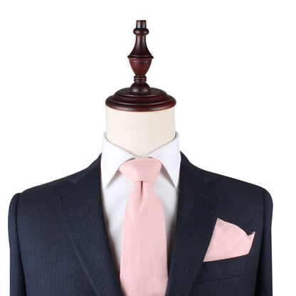 A mannequin exuding soft elegance in a blush pink suit and Blush Pink Skinny Necktie and Pocket Square Set.