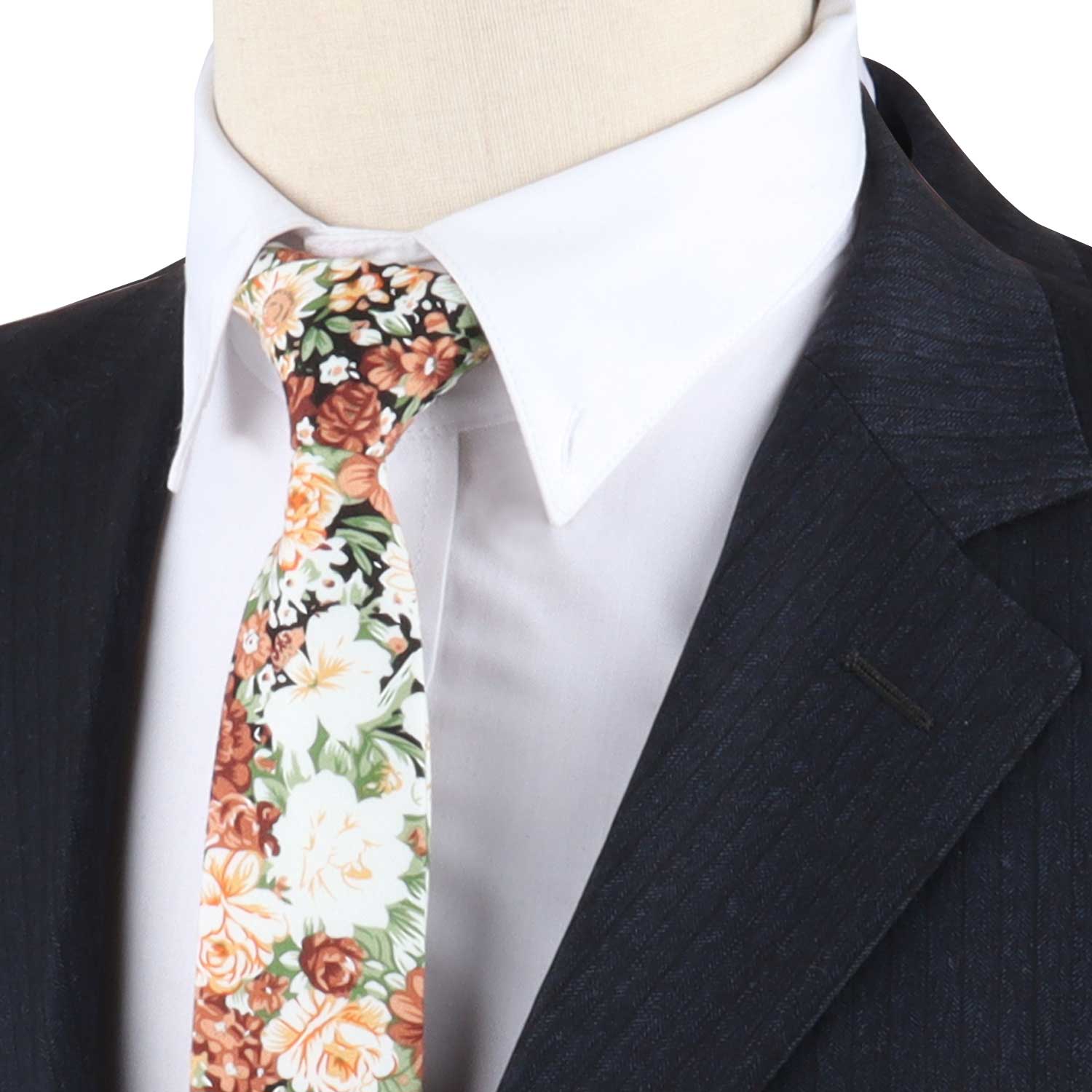 Close-up of a person wearing a dark pinstripe suit, a white dress shirt, and a Botanical Pattern Tie showcasing various colors including orange and green. Truly, Nature’s masterpiece meets dapper design.