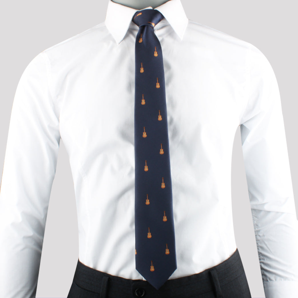 A man in a white dress shirt and dark pants with a Brown Guitar Print Necktie featuring small orange flame motifs.