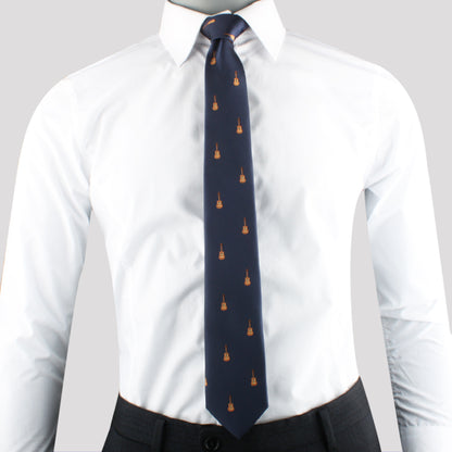A man in a white dress shirt and dark pants with a Brown Guitar Print Necktie featuring small orange flame motifs.
