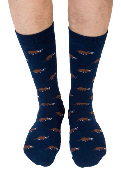 Person showcasing the Triceratops Socks with flair, featuring blue hues and brown prehistoric dinosaur designs.