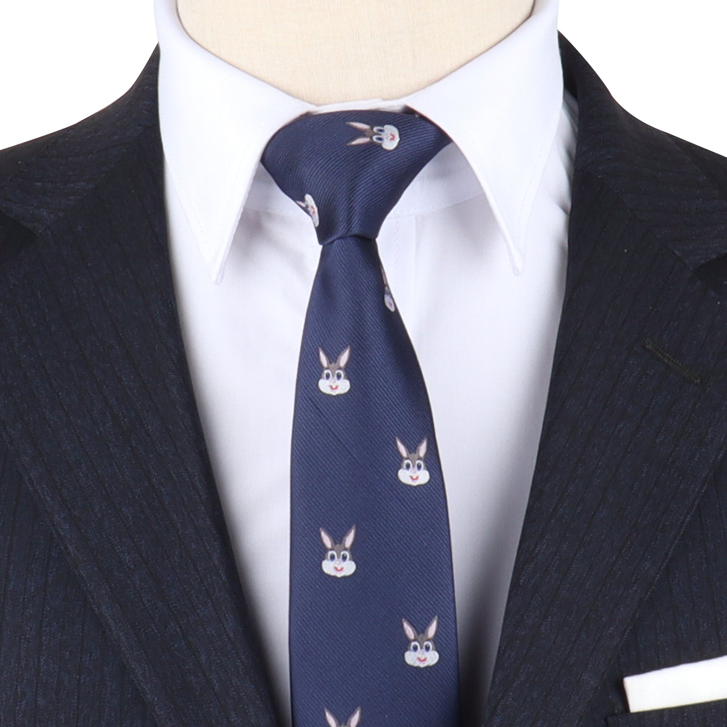 A person exudes charming sophistication in a dark pinstripe suit and white shirt, accessorized with the Bunny Skinny Tie, which features a playful pattern of cartoon rabbit faces.