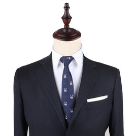 A mannequin exudes charming sophistication in a dark suit paired with a white shirt and the Bunny Slim Tie. The ensemble is accented by a white pocket square, showcasing elegant clothing that speaks to sophisticated fashion.