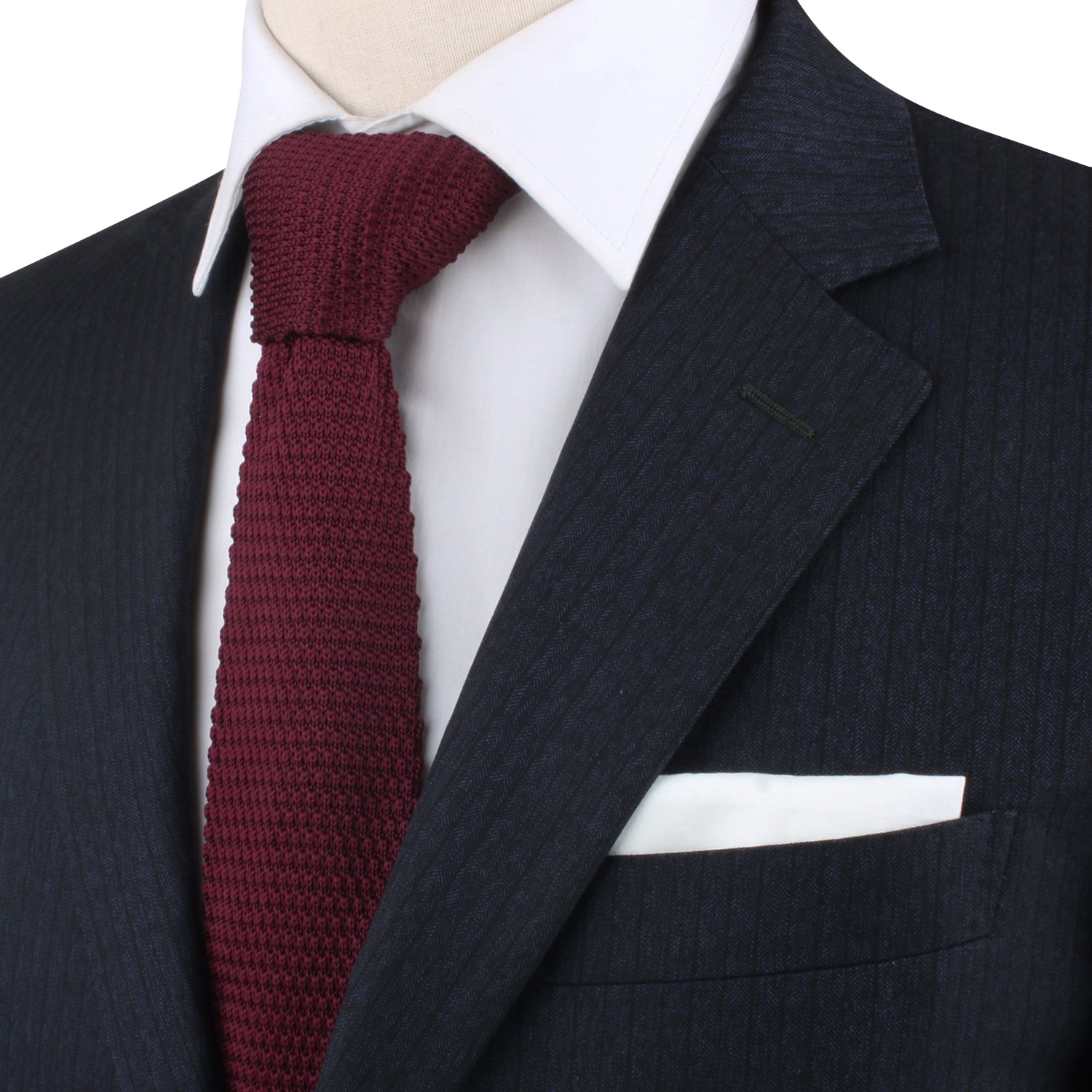 A close-up of a person wearing a dark pinstripe suit, white shirt, Maroon Knitted Skinny Tie, and white pocket square. The warm hues of the ensemble exude cozy elegance. Face is not visible.