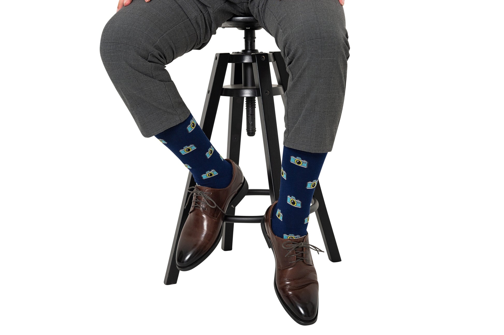 A man sitting on a stool wearing a pair of Camera Socks.
