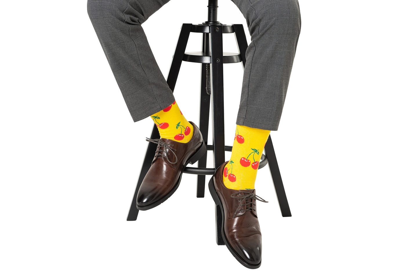 A person sporting flashy yellow Cherry Socks and trendy brown shoes.