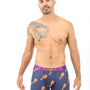 Clad in Chicken Boxers, a person stands in cozy comfort, sporting a quirky chicken drumstick pattern on their boxer briefs and revealing a tattoo on their shoulder.