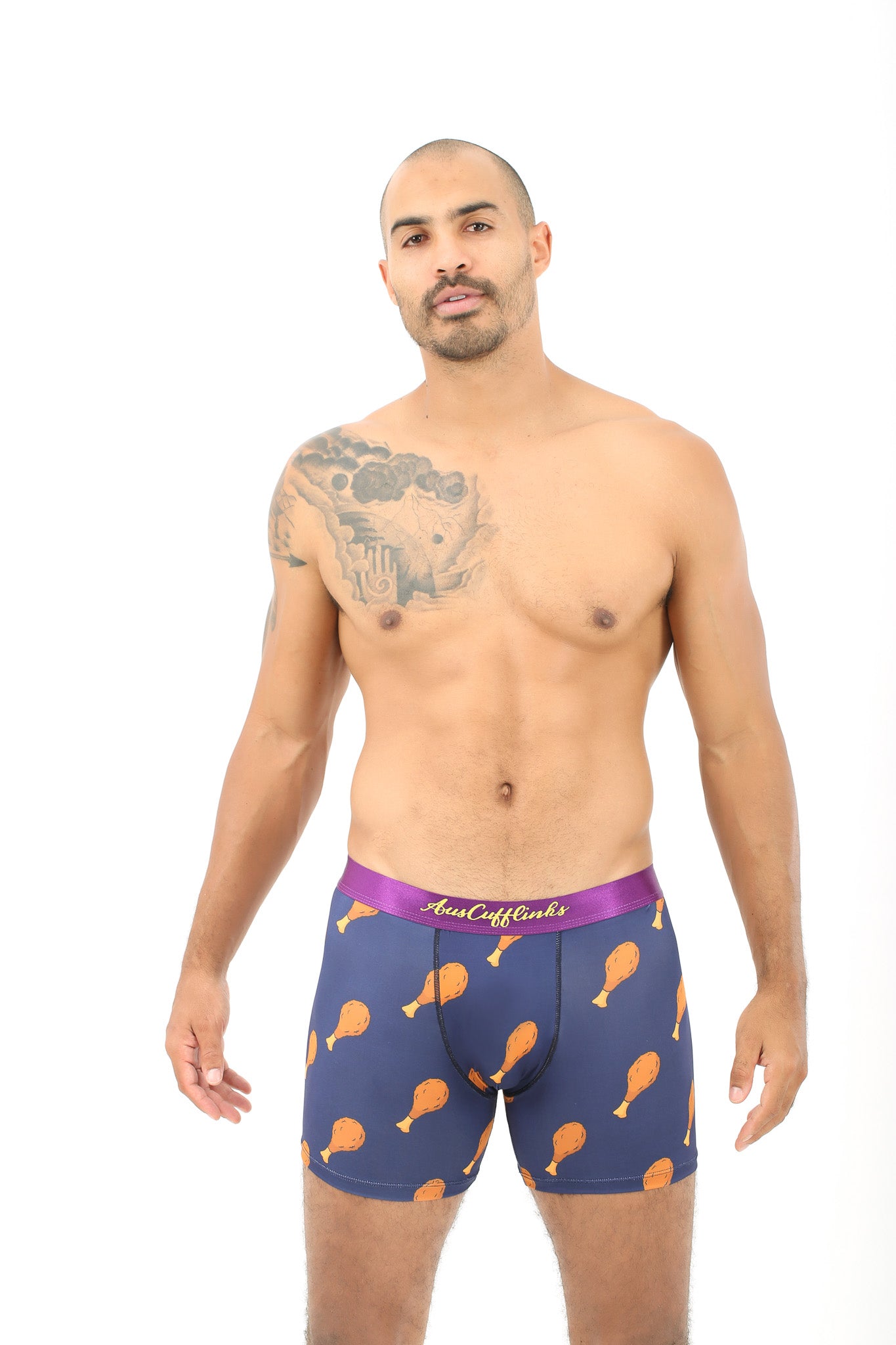 Clad in Chicken Boxers, a person stands in cozy comfort, sporting a quirky chicken drumstick pattern on their boxer briefs and revealing a tattoo on their shoulder.