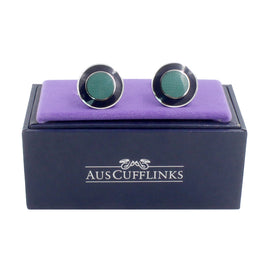 A pair of Circular Teal Cufflinks in a purple box with Oceanic charm.