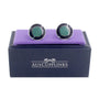 A pair of Circular Teal Cufflinks in a purple box with Oceanic charm.