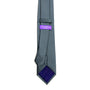 A Classic Grey Skinny Tie with a purple label on it.