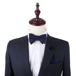 A mannequin with a Classic Navy Self Tie Bow Tie and navy suit.