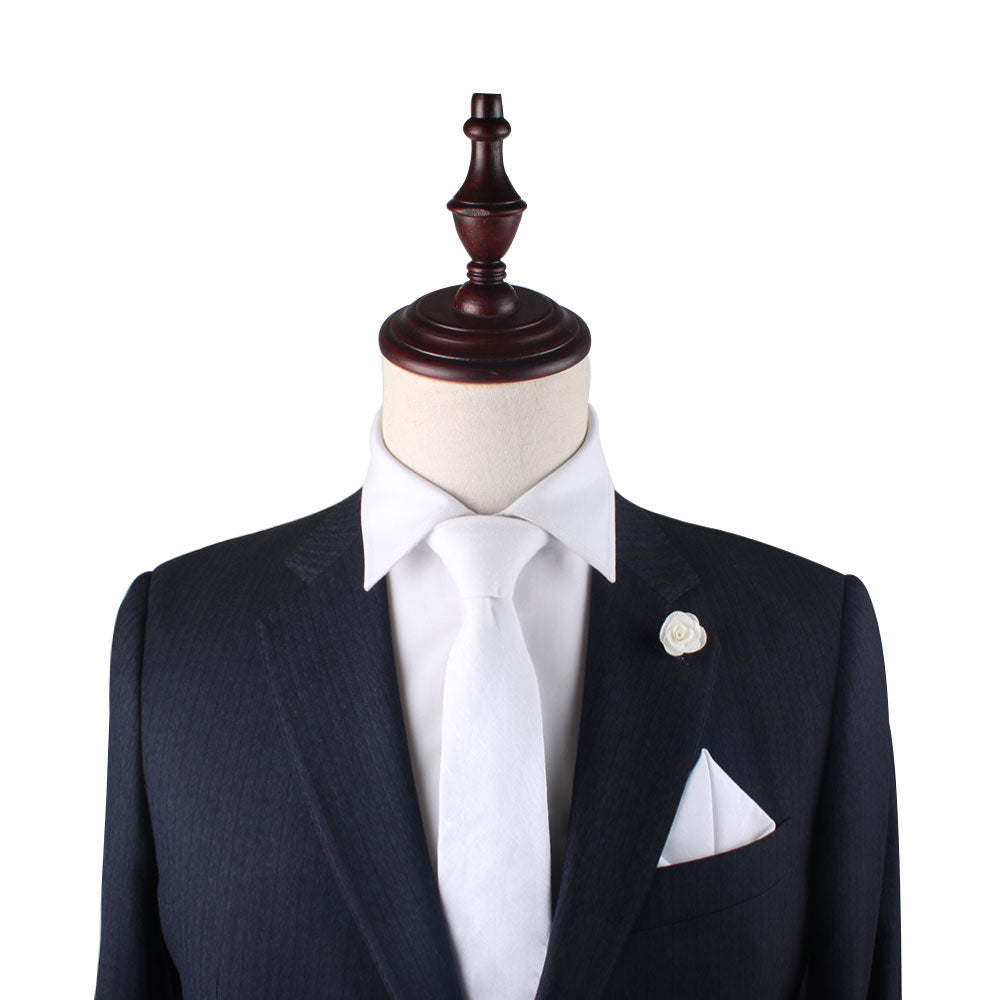 Mannequin dressed in a black suit with a white shirt, the Classic White Cotton Skinny Tie, handkerchief, and a rose lapel pin that adds a touch of sartorial elegance.