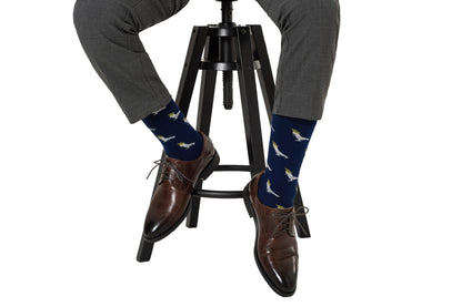 A man sitting on a stool wearing a pair of Cockatoo Socks.