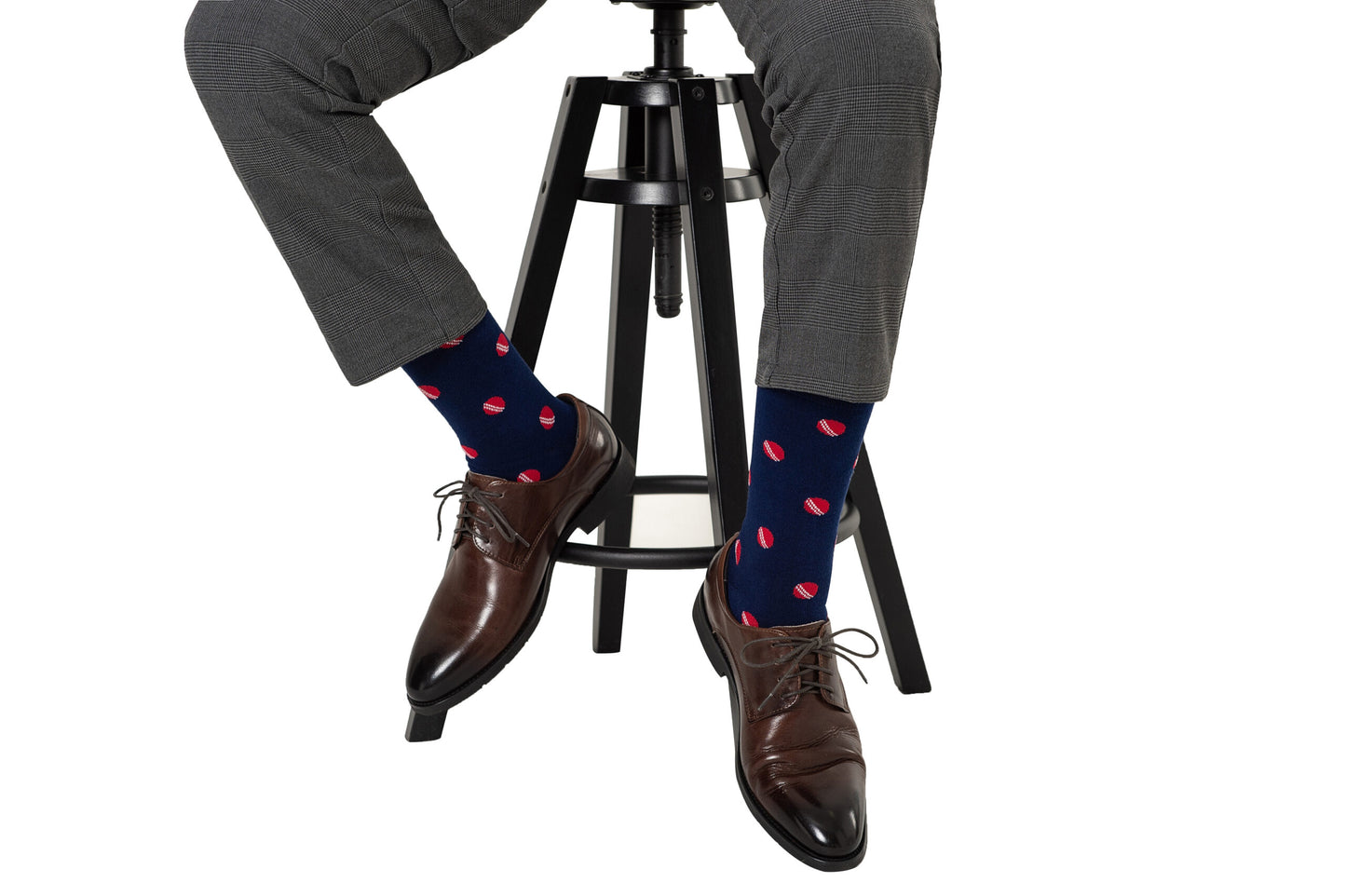 A man sitting on a stool wearing a pair of Cricket Socks.