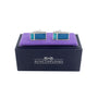 The Aqua Rectangle Cufflinks exude oceanic elegance, perched on a purple cushion and displayed atop a navy box labeled "AUSCUFFLINKS.